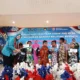 Ketua TP PKK Basel Elizia Riza Herdavid menyerahkan bantuan kepada peserta khitanan massal dalam rangka HKG PKK ke-53 di Gedung Serbaguna Basel, (2/7)