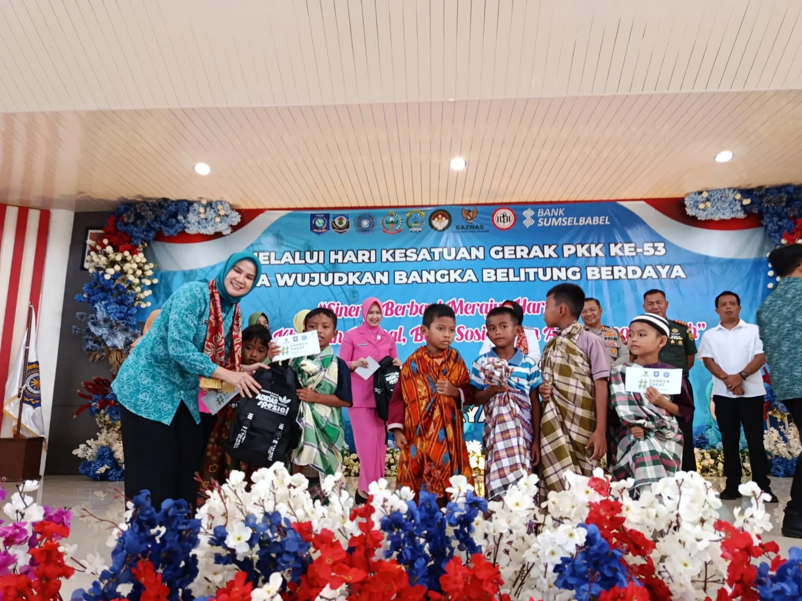 Ketua TP PKK Basel Elizia Riza Herdavid menyerahkan bantuan kepada peserta khitanan massal dalam rangka HKG PKK ke-53 di Gedung Serbaguna Basel, (2/7)