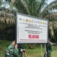 Personel TNI memasang papan larangan di kebun sawit terkait Perpres No. 5 Tahun 2025. (Foto/Istimewa)