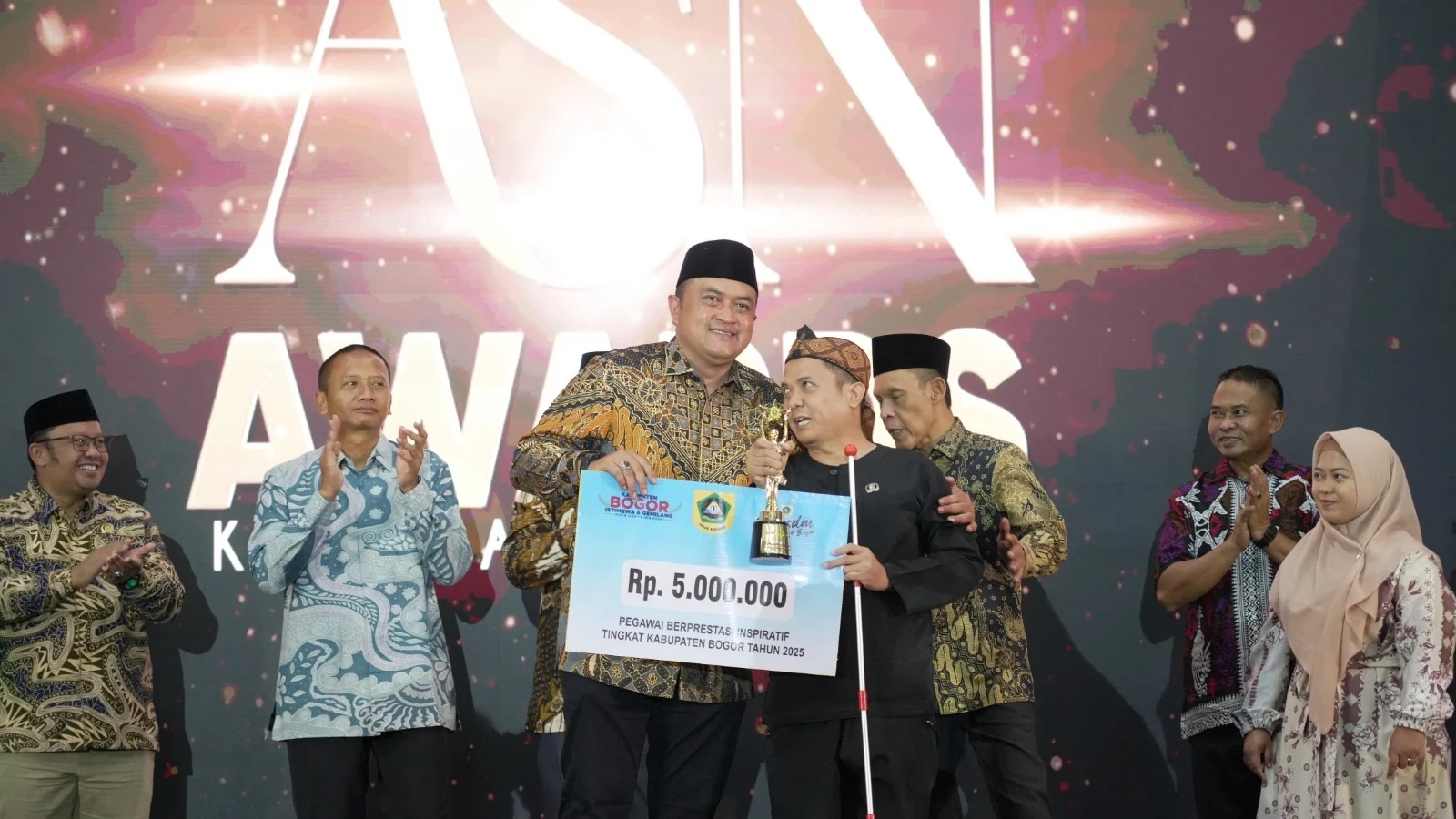 Bupati Bogor Rudy Susmanto menyerahkan penghargaan ASN Terinspiratif kepada M. Arif Budiman pada ajang ASN Award Kabupaten Bogor Tahun 2025 di Gedung Tegar Beriman, Cibinong, Selasa (16/12/2025). Foto: Sumber bogorkab.go.id